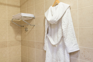 white terry bathrobe hanging in the hotel bathroom