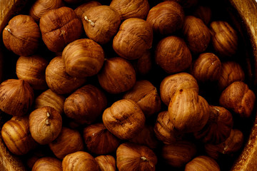 Macro shot of raw hazelhuts in a wooden bowl. Horizontal composition