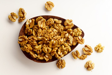 Raw walnuts on wooden tray on white background isolated with copy space. Overhead image