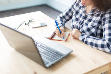 Business and people concept - close up woman is working at the office with laptop