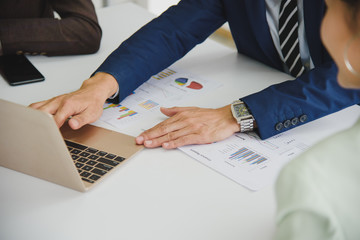 Three Business People Meeting working in office for discussing with a computer laptop and paper document sheet