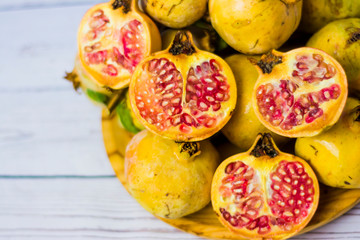Pomegranate fruit on a wooden plate