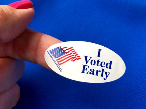 I Voted Sticker On A Woman’s Finger With Blue Background 