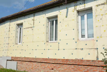 Old house brick wall renovation with facade styrofoam insulation.