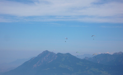 paragliders flying in the sky above the mountains of Switzerland