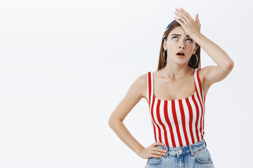 Gosh why me. Portrait of unhappy displeased and annoyed young arrogant woman in striped top facepalming with irritation breathing out with opened mouth and rolling eyes from annoyance and exhaust