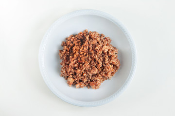 top view of spelt with tuna and tomato sauce, the dish is on white background
