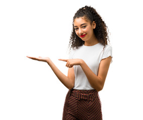 Young girl with curly hair holding copyspace imaginary on the palm to insert an ad on white...