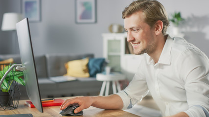 Portrait of the Handsome Mobile Application Designer Working On Personal Computer at His Desk.