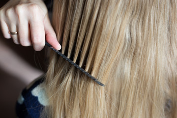 blonde girl is combing her hair