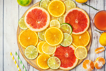 Mixed Fresh slices citrus fruit on a round wooden Board on a light background. Top view