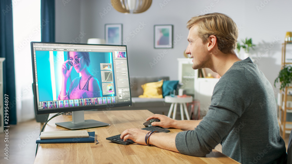 Poster professional photographer works in photo editing app / software on his personal computer. photo edit