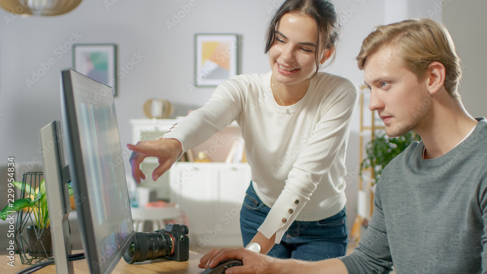 Poster male and female professional editors talk while working in photo editing app / software on a persona