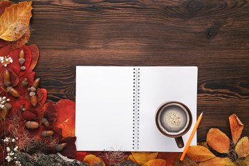 autumn leaves, cookies and paper notebook on wooden background