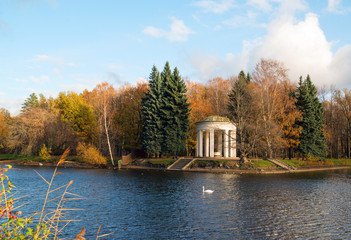 Fototapeta na wymiar Gazebo-rotunda on the banks of the Swan pond in the autumn.