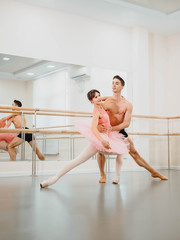 Professional, emotional ballet dancers practicing in the gym or hall with minimalism interior. Couple dancing a sensual dance before performance © kohanova1991
