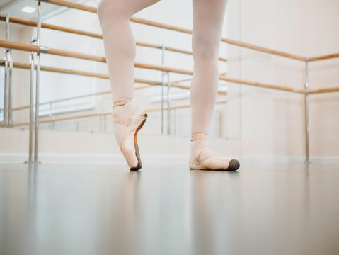 Close up legs in pointe. Training before performance. Woman practicing in classical ballet in tutu dress in gym or ballet hall. Performing sensual dance