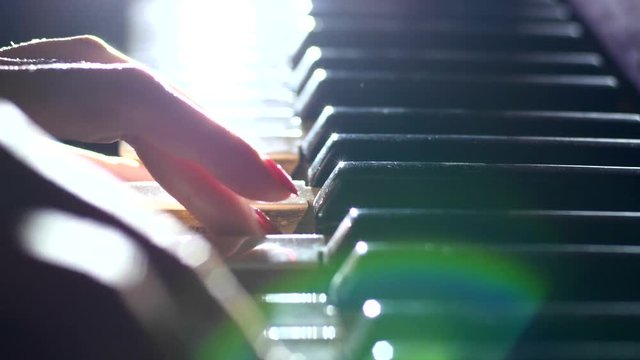 Playing the piano - fingers of a pianist in the rays of light