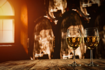 Two glasses with wine on a wooden table in an autumn setting   