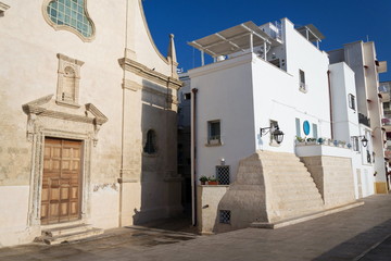 Seafront with catholic Church Chiesa San Salvatore in Monopoli, Adriatic sea, Italy, sunny summer day
