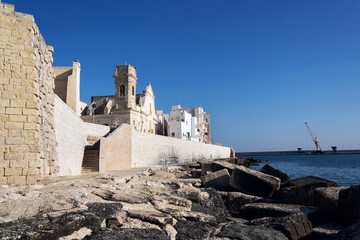 Seafront with catholic Church Chiesa San Salvatore in Monopoli, Adriatic sea, Italy, sunny summer...