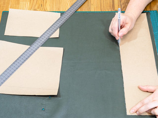 craftsman draws on green leather using the pattern - Powered by Adobe