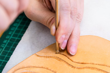 craftsman stamps the relief on surface of leather