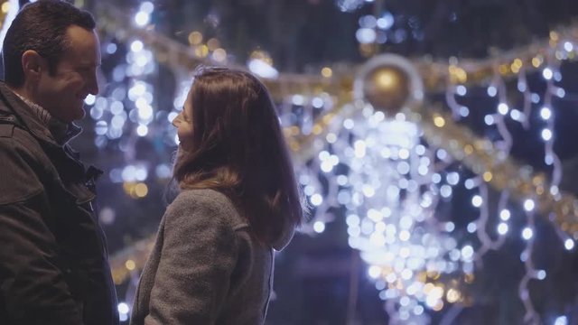 Romantic couple tender gesture at Christmas tree, special moments of joy