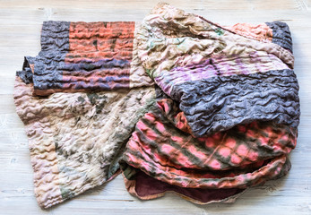 folded silk patchwork scarf on wooden table