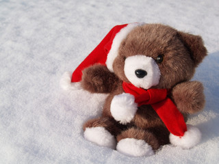 Teddy als Weihnachtsmann sitzt im Schnee