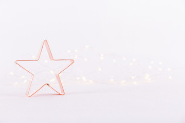 Star  Copper cookie cutter on white sparkling background with bokeh lights. Holiday Christmas and New Year background