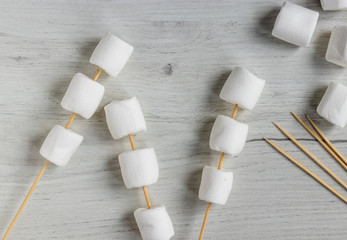 Marshmallow skewers on the wooden background