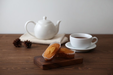 木のテーブルにのせた カップケーキ 紅茶 ティー ポット カップ