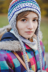 Portrait of young woman wearing autumn hat outdoors in the park..