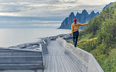 A man walking on the parapet toward rocks