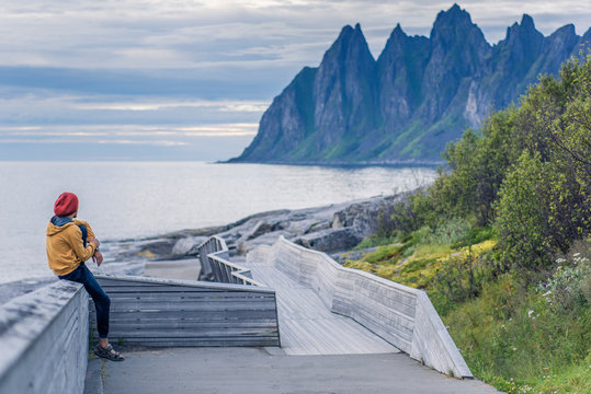 A man sitting on the parapet and looking at rocks