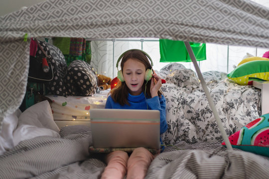 tween girl in her room, under a cubby house, listening to music