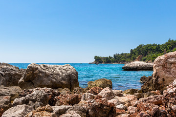 Stoned shore of the Adriatic sea in Montenegro, nature landscape, vacations to the summer paradise