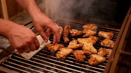 Cooking meat on the grill - sausages and chicken wings