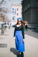  Young woman in blue beret and sunglasses in the city. winter clothes . elegant image for everyday life.