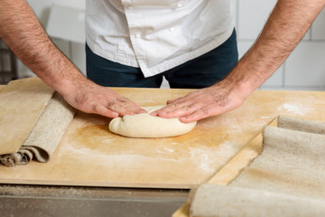 Baker is kneading yeast dough