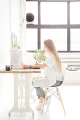Young business woman working at home behind a laptop. Creative Scandinavian style workspace