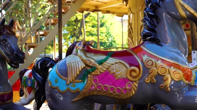 Stunning close up shot of retro circus carousel vintage merry go round horse ride kids attraction spinning at carnival