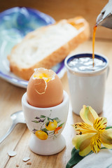Breakfast of coffee with egg and toast on a wooden table