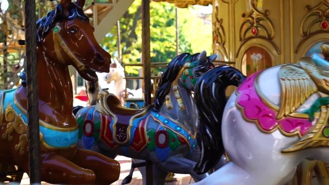 Beautiful close view on vintage circus carousel retro merry go round horse ride attraction spinning at funfair carnival