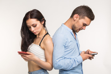 Smartphone addiction concept - Upset couple standing back to each other on white background