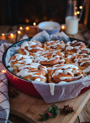 Close-up of homemade cinnamon rolls with cream cheese icing,on wooden background