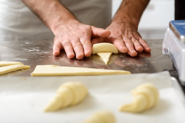 Dough triangles rolling into croissants