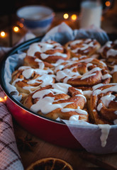 Close-up of homemade cinnamon rolls with cream cheese icing, on wooden background
