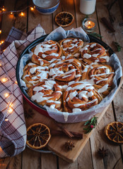 Homemade cinnamon rolls with cream cheese icing, on wooden background